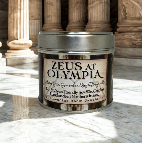 Candle jar labeled 'Zeus at Olympia' on a marble surface with classical columns in the background