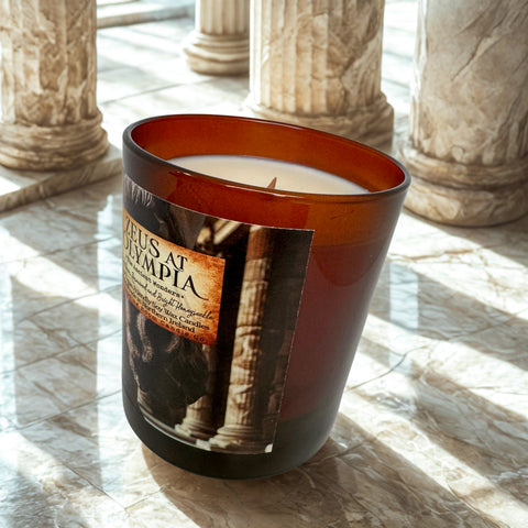 Candle with a label featuring ancient architecture on a marble surface