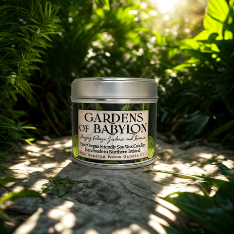 Candle jar labeled 'Gardens of Babylon' on a natural background with greenery.