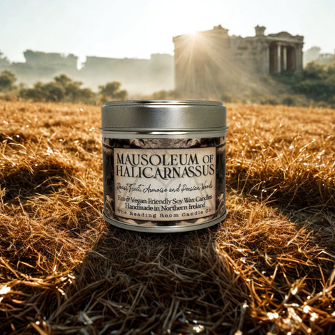 Candle tin labeled 'Mausoleum of Halicarnassus' in a field with ancient ruins in the background