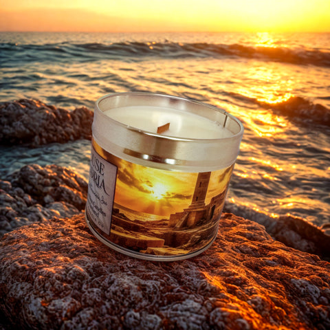 Candle in a glass jar with a sunset design on a rock by the sea