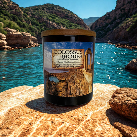 Candle labeled 'Colossus of Rhodes' on a rocky surface with a scenic background