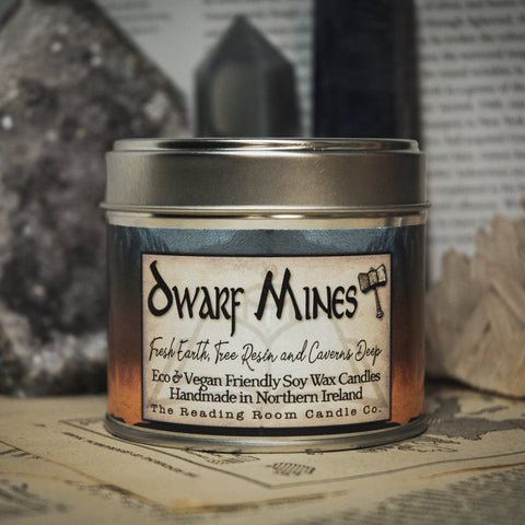 Soy Wax Candle labeled 'Dwarf Mines' on a surface with rocks and books in the background