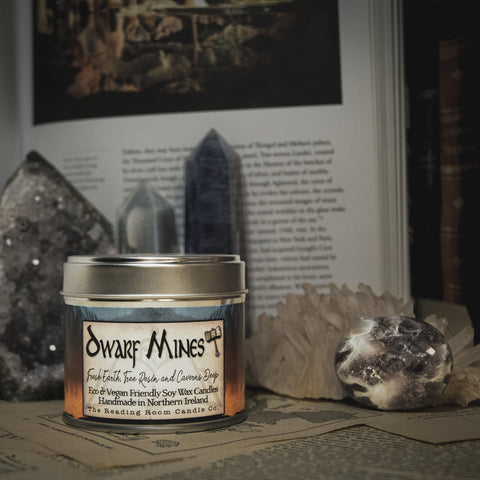 Soy Wax Candle labeled 'Dwarf Mines' on a surface with rocks and books in the background