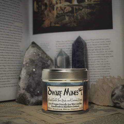 Soy Wax Candle labeled 'Dwarf Mines' on a surface with rocks and books in the background