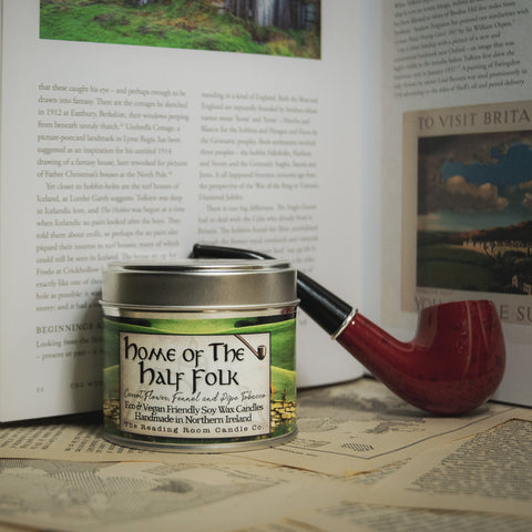 Soy Wax Candle labeled 'Home of the Half Folk' on a table with an open book 