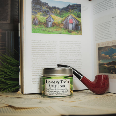 Soy Wax Candle labeled 'Home of the Half Folk' on a table with an open book 