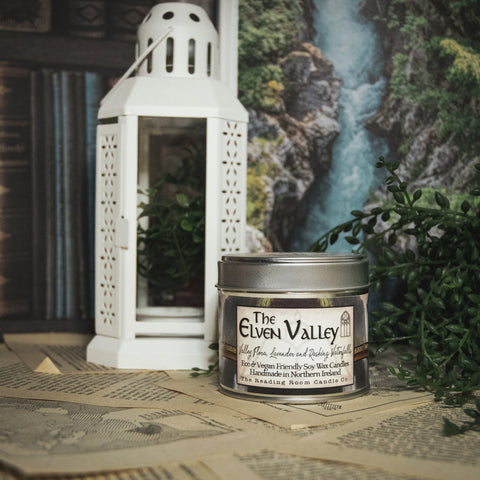 Soy Wax Elven Valley candle in a tin with a decorative background
