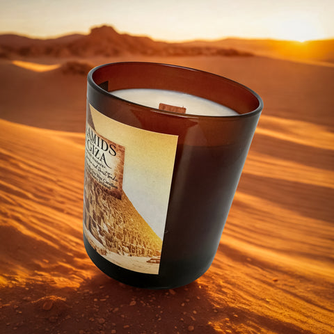 Candle with a label in the sand dunes during sunset