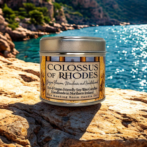 Colossus of Rhodes candle on a rocky outcrop with ocean and mountains in the background